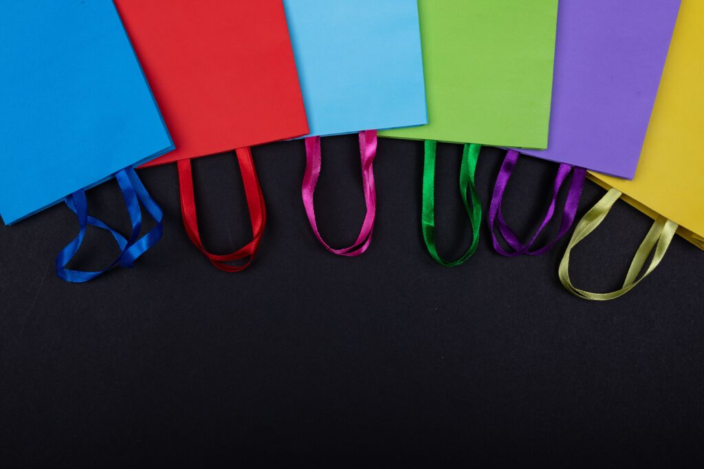 A vibrant collection of colorful paper bags displayed on a black backdrop.